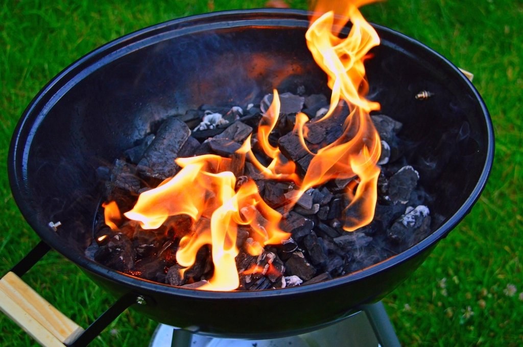 Charcoal flames in a kettle grill