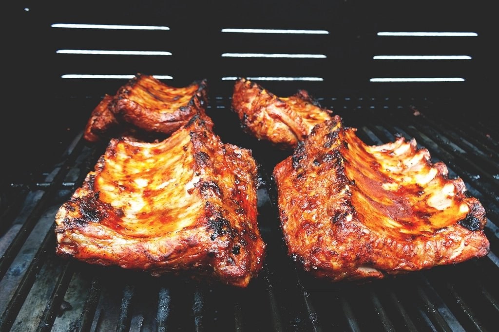 Barbecue ribs on a grill with tomatoes